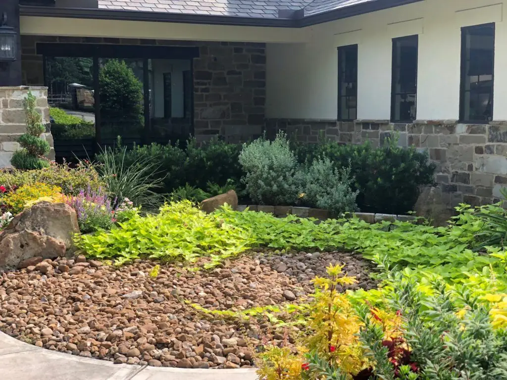 Commercial-style stone landscape with dry creek and shaped plantings