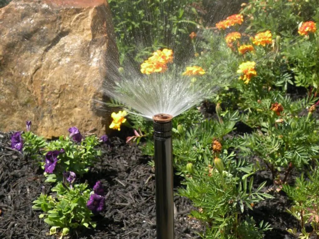 PGS-installed sprinkler watering a flower bed